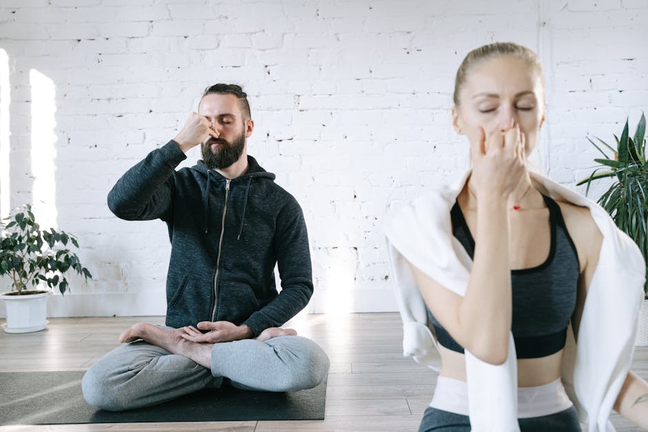 Woman meditating peacefully in a simple yoga pose in a bright room.